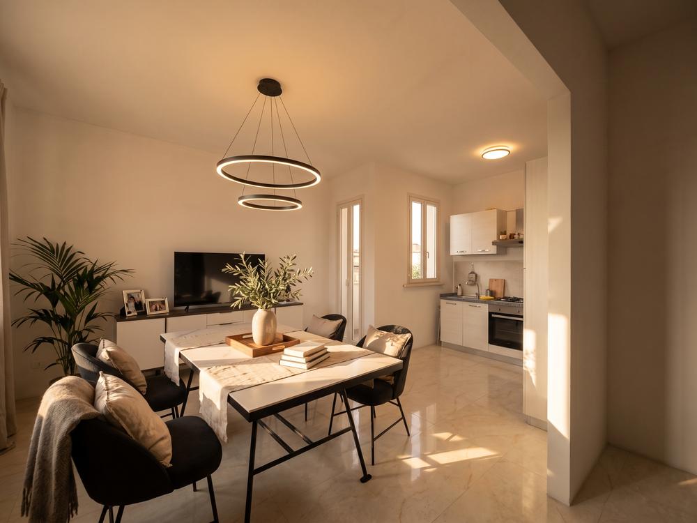 Rendering di progetto: angolo pranzo con lampada a sospensione e porta a battente